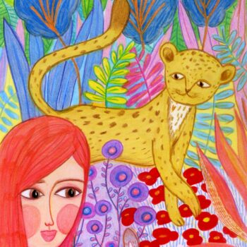 A beautiful redheaded girl and her baby tiger play and watch each other in between the wildflowers and vegetation